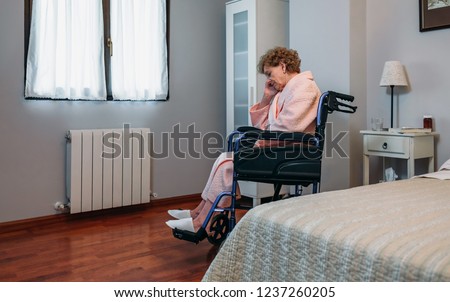 Senior woman in a wheelchair alone