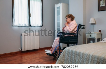 Similar – Senior woman in a wheelchair alone