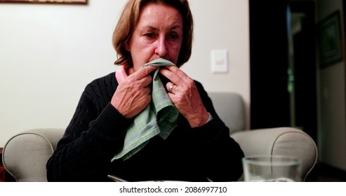 Senior Woman Wiping Mouth With Napkin