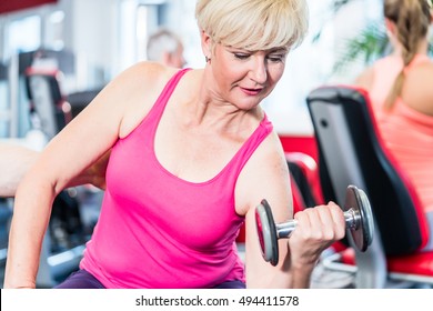 Senior Woman Working Out With Dumbbells At The Gym