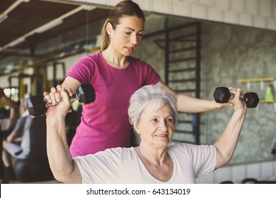 Senior woman workout in rehabilitation center. Personal trainer helping senior woman - Powered by Shutterstock