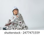 Senior woman wrapped in a survival sheet