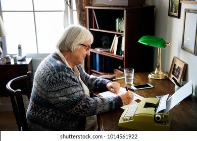 Senior Woman Writing On A Paper