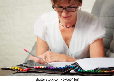 Senior WomanDrawing In Coloring Book - Powered by Shutterstock