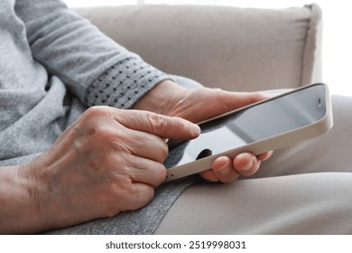 Senior woman's hand operating a smartphone - Powered by Shutterstock