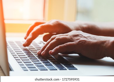 Senior Woman's Hands Typing On Keyboard, Old Woman Working On Laptop Computer At Home