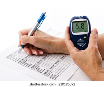 Senior Woman's Hands Writing Data From Glucometer To Medical Form On White Background