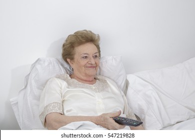 Senior women in bed watching tv