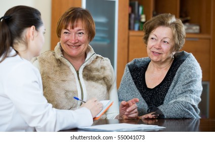 Senior women discussing health problems with therapeutist in clinic