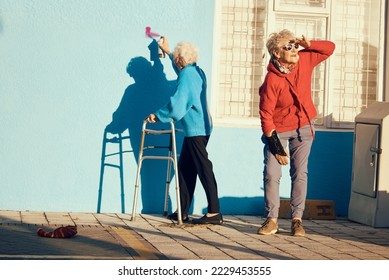 Senior women, friends and spray paint for vandalism, graffiti and street art drawing on nursing home building wall. Crazy old people break law with illegal pop art outdoor in retirement for fun - Powered by Shutterstock