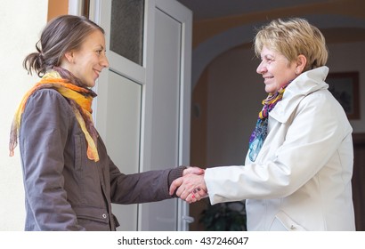 Senior women greeting young girl in the doorway
