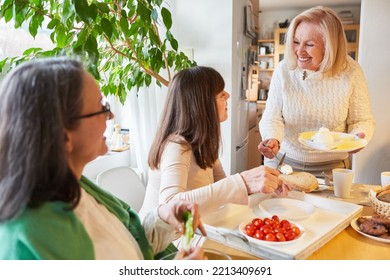 Senior Women Group As Girlfriends Having Fun At Morning Brunch Or Breakfast In Kitchen