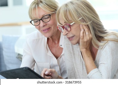Senior women at home using digital tablet