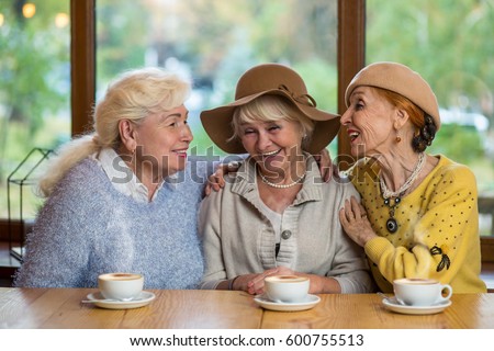 Senior women laughing at table. Happy ladies in cafe. Friendship tested by years.