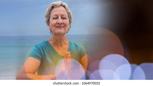 Senior women meditating on beach against sky - Powered by Shutterstock