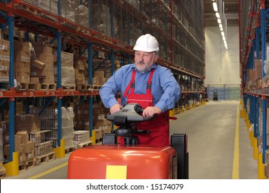 A senior worker driving the fork lift through a storage room in a factory - Powered by Shutterstock