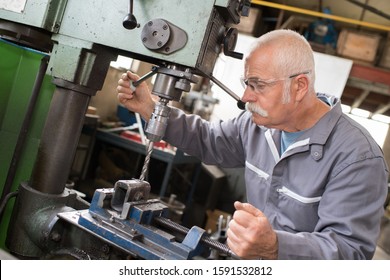 senior worker using bench drill - Powered by Shutterstock