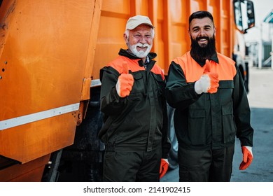 Senior and young garbage men working together on emptying dustbins for trash removal. - Shutterstock ID 2141902415