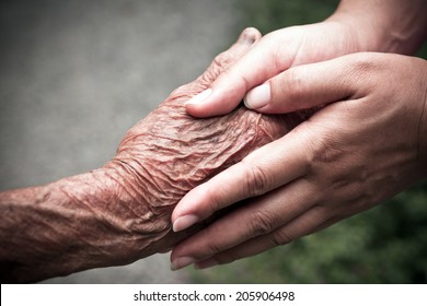 Senior and young holding hands