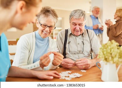 Seniors with Alzheimer's disease or dementia playing puzzle with senior care