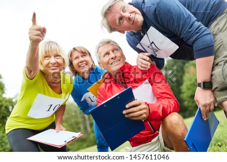 Seniors with clipboard at a geocaching game or scavenger hunt