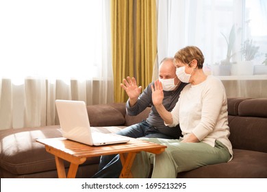 Seniors couple  grandmother and grandfather wearing medical face mask and using laptop Communicate with grandchildren online at home. quarantine. standing in home. chelter in place. - Powered by Shutterstock