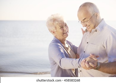 Seniors Dancing On The Beach In Great Moods
