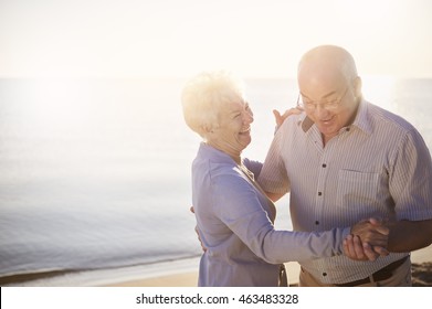 Seniors Dancing On The Beach On The Sunrise
