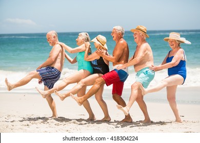 Seniors Dancing In A Row At The Beach On A Sunny Day