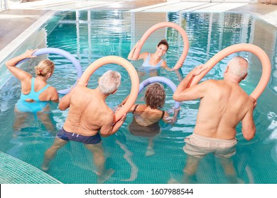 Seniors Do Back Training With The Swimming Noodle In The Pool