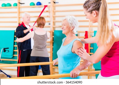 Seniors In Physical Rehabilitation Therapy With Trainer