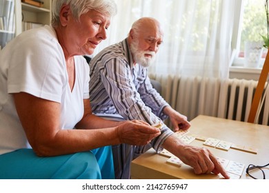 Seniors play dominoes at home or in a retirement home as a memory training and brain teaser - Powered by Shutterstock