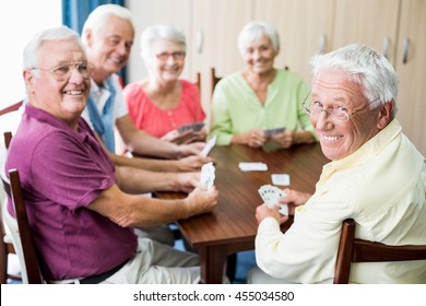 Seniors playing cards together in a retirement home - Powered by Shutterstock