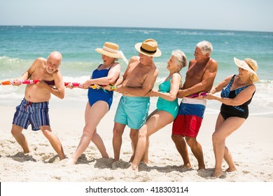 Seniors playing tug of war at the beach on a sunny day - Powered by Shutterstock