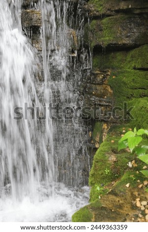 A sensational waterfall splashing water over the natural rocks and stones.