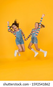 sense of freedom. summer vacation together. free and energetic beauty. happy childhood. real friendship. best friends forever. small sisters have fun. little girls jump yellow background. - Shutterstock ID 1592541862