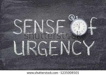 sense of urgency phrase handwritten on chalkboard with vintage precise stopwatch used instead of O