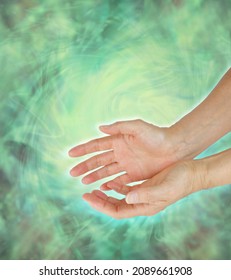 Sensing green healing energy field  - female cupped hands with surrounded by flowing swirling high vibrational green energy  with copy space for message
