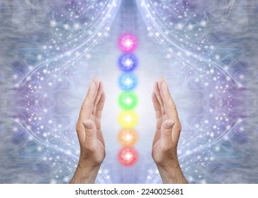 Sensing Seven Chakras and Sending Healing - Male parallel hands with 7 rainbow coloured energy centres between against a blue flowing sparkling background and copy space 
 - Shutterstock ID 2240025681