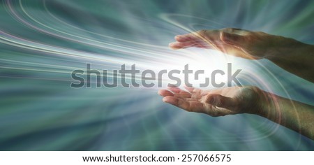 Sensing Supernatural Energy - Parallel female hands with a swirling light burst between on a blue energy field background