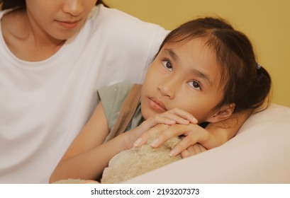 Sensitive Asian Daughter With A Weak Heart And An Unhappy Face, Worried About Something, With A Caring Mother At Her Side To Help Relieve Stress.
