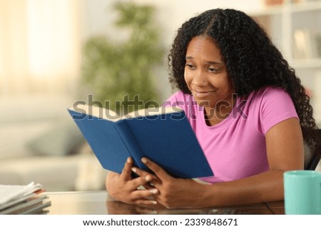 Sensitive black reader reading a paper book at home