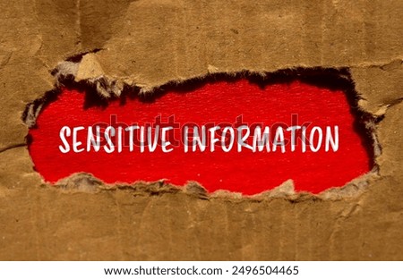 Sensitive information message written on torn cardboard paper with red background. Conceptual sensitive information symbol. Copy space.