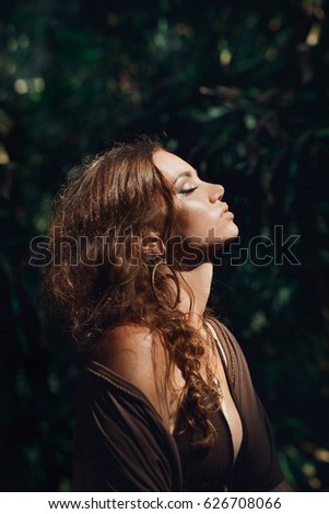 sensitive portrait of beautiful young woman in forest