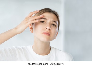 Sensitive Skin. Acne Problem. Zit Treatment. Frustrated Young Woman Touching Itchy Dry Face Wrinkle On White Defocused Background.