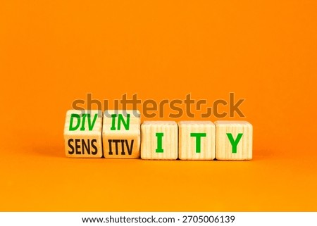 Sensitivity or divinity symbol. Concept words Sensitivity or Divinity on wooden cubes. Beautiful orange background. Psychology sensitivity or divinity concept. Copy space.