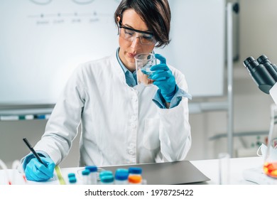 Sensory Analysis Of Sea Fish Sample In A Test Tube. Food Safety Inspector Smelling Sample In Laboratory