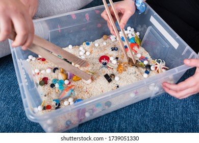 Sensory Integration Therapy - Picking Small Objects With Tongs From A Rice Container (close Up Picture)