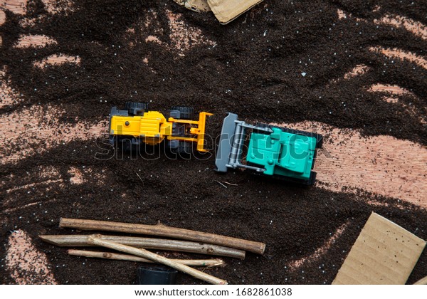 Sensory play with construction trucks toys,\
dirt and some recyclable\
materials