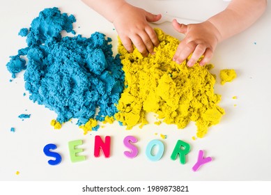Sensory word, magic kinetic sand and kids hands close up. Early sensory education. Kids's sensory experiences,  games for fine motor skills. Therapy hand, development of fine motor, autism
